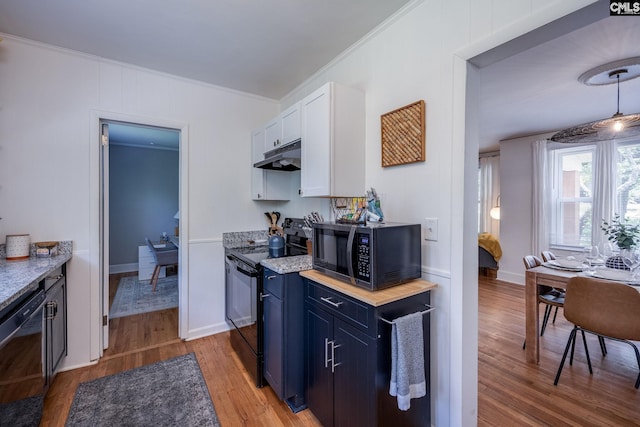 39 Downing, Columbia, SC 29209 - kitchen featuring black appliances, under cabinet range hood, light wood-style flooring, blue cabinetry, and ornamental molding