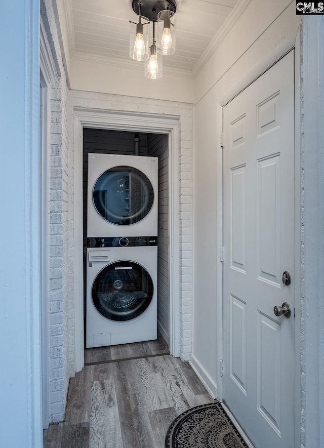 39 Downing, Columbia, SC 29209 - laundry room featuring stacked washer / drying machine, crown molding, and wood finished floors