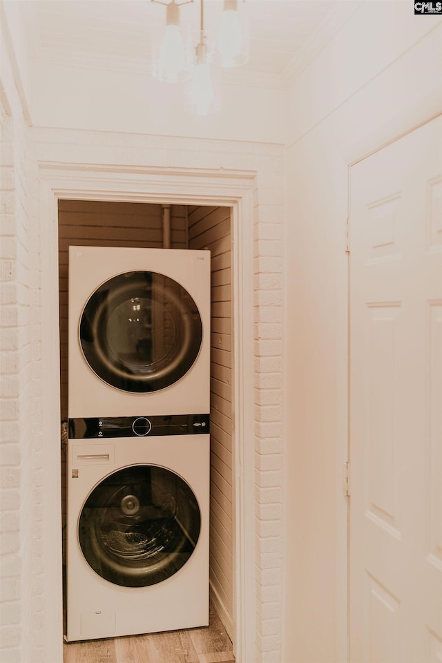 39 Downing, Columbia, SC 29209 - washroom with stacked washer / dryer, ornamental molding, a chandelier, and wood finished floors