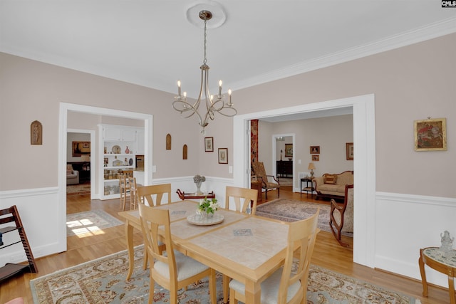 8 Sand Spur Rd, Columbia, SC 29223 - dining room with a wainscoted wall, a chandelier, ornamental molding, and light wood finished floors