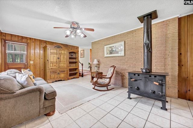 159 Rogers Rd, Saluda, SC 29138 - living area featuring brick wall, ceiling fan, a textured ceiling, wooden walls, and a wood stove