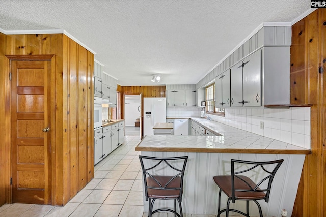 159 Rogers Rd, Saluda, SC 29138 - kitchen featuring white appliances, a textured ceiling, a peninsula, backsplash, and light tile patterned flooring