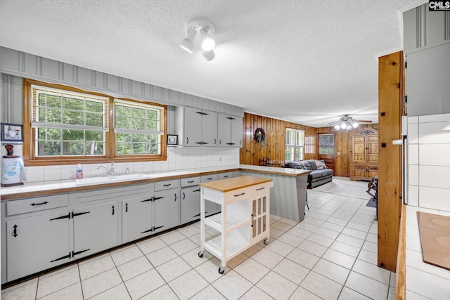 159 Rogers Rd, Saluda, SC 29138 - kitchen featuring a textured ceiling, a peninsula, wooden walls, open floor plan, and a ceiling fan
