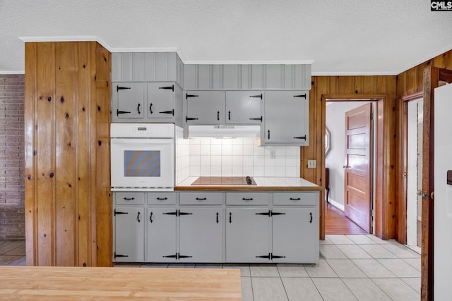159 Rogers Rd, Saluda, SC 29138 - kitchen with white oven, black electric cooktop, gray cabinets, ornamental molding, and a textured ceiling