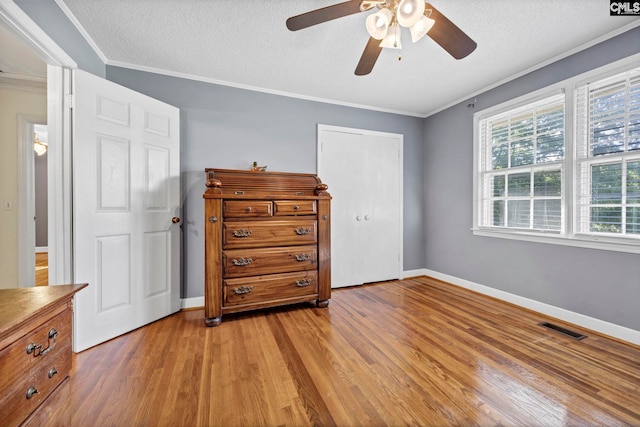 159 Rogers Rd, Saluda, SC 29138 - bedroom with light wood finished floors, crown molding, a textured ceiling, a ceiling fan, and a closet