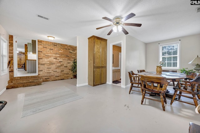 159 Rogers Rd, Saluda, SC 29138 - dining room featuring brick wall, ceiling fan, finished concrete flooring, and a textured ceiling