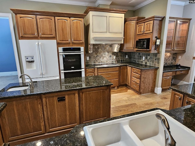 116 Avington Ln, Columbia, SC 29229 - kitchen with black appliances, ornamental molding, dark stone counters, backsplash, and brown cabinets