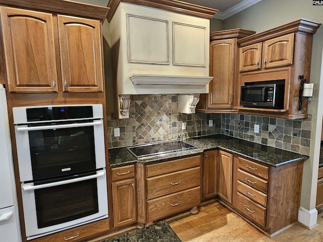 116 Avington Ln, Columbia, SC 29229 - kitchen with double oven, black electric stovetop, crown molding, dark stone counters, and fridge