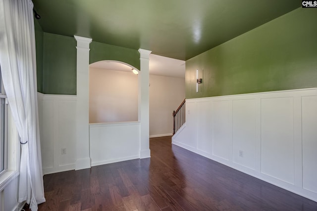 22 Kentucky Derby Ct, Lugoff, SC 29078 - empty room with wood finished floors, arched walkways, a decorative wall, wainscoting, and ornate columns