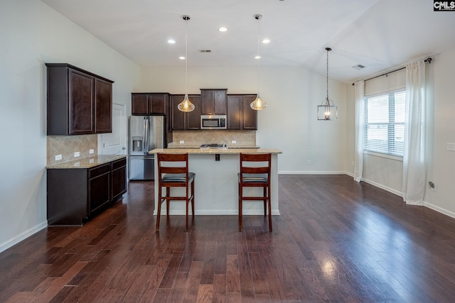 22 Kentucky Derby Ct, Lugoff, SC 29078 - kitchen with stainless steel appliances, dark brown cabinetry, a kitchen bar, tasteful backsplash, and lofted ceiling
