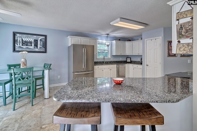 4 Beckworth Ct, Irmo, SC 29063 - kitchen with appliances with stainless steel finishes, a peninsula, a textured ceiling, white cabinets, and dark stone countertops