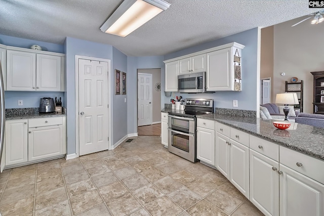 4 Beckworth Ct, Irmo, SC 29063 - kitchen with appliances with stainless steel finishes, a textured ceiling, white cabinets, dark stone countertops, and light stone finish flooring