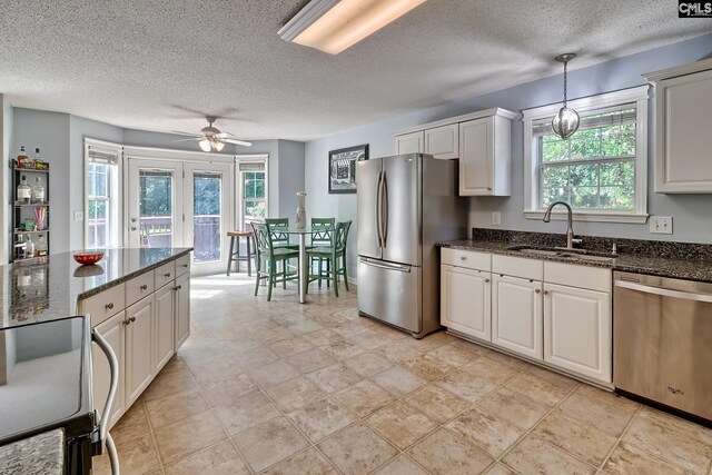 4 Beckworth Ct, Irmo, SC 29063 - kitchen with stainless steel appliances, a ceiling fan, a textured ceiling, dark stone countertops, and pendant lighting