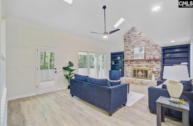 303 High Grove Rd, Summerville, SC 29485 - living room with a skylight, light wood-style flooring, vaulted ceiling, a brick fireplace, and built in features