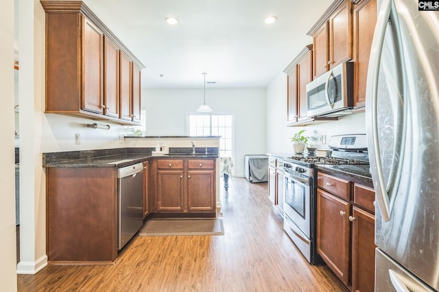 512 Eagles Rest Dr, Chapin, SC 29036 - kitchen featuring appliances with stainless steel finishes, light wood finished floors, a peninsula, dark stone countertops, and recessed lighting