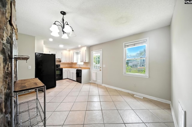 224 Ashton Cir, Lexington, SC 29073 - kitchen with black appliances, a chandelier, light countertops, white cabinets, and light tile patterned floors