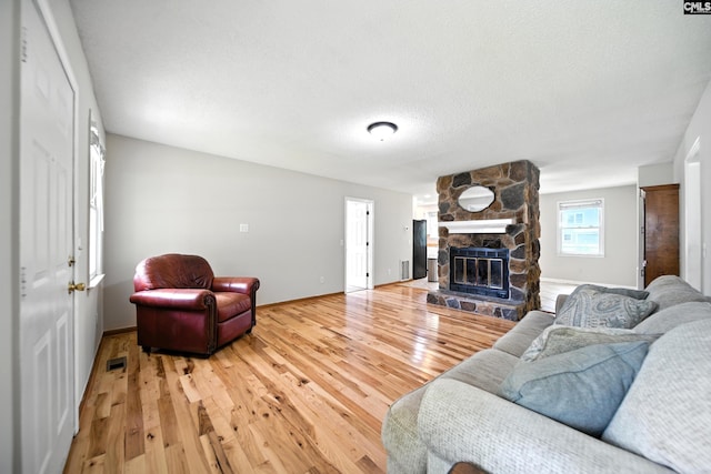 224 Ashton Cir, Lexington, SC 29073 - living room featuring hardwood / wood-style flooring, a stone fireplace, and a textured ceiling