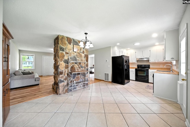 224 Ashton Cir, Lexington, SC 29073 - kitchen featuring black appliances, a chandelier, light countertops, open floor plan, and under cabinet range hood