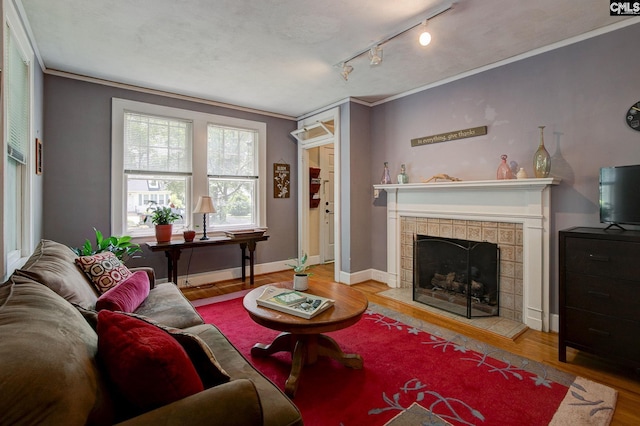 2817 Duncan St, Columbia, SC 29205 - living area with wood finished floors, a tile fireplace, crown molding, and track lighting