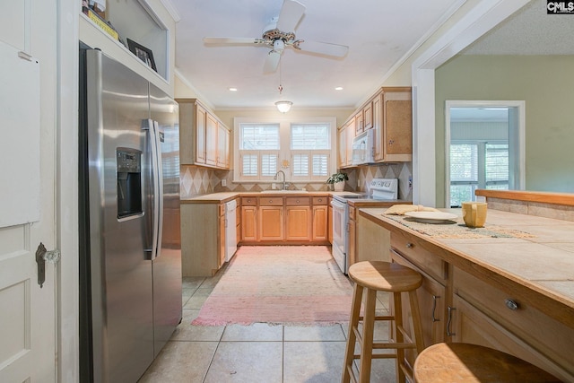 2817 Duncan St, Columbia, SC 29205 - kitchen featuring white appliances, light tile patterned flooring, a ceiling fan, decorative backsplash, and light brown cabinetry