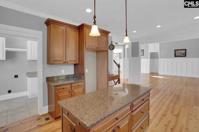 100 Julia Ct, Lexington, SC 29072 - kitchen with light stone counters, brown cabinetry, light wood-style floors, recessed lighting, and hanging light fixtures