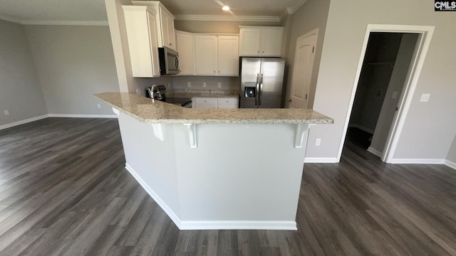 1020 Winter Way, Lexington, SC 29073 - kitchen with stainless steel appliances, ornamental molding, a peninsula, white cabinetry, and a breakfast bar area