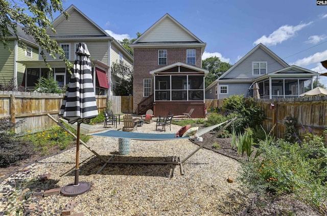 3722 Heyward St, Columbia, SC 29205 - rear view of house featuring a sunroom, an outdoor fire pit, brick siding, and a fenced backyard