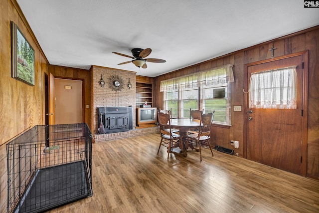 3204 Windmill Rd, Leesville, SC 29070 - dining area with wood walls, a wood stove, ceiling fan, built in features, and wood finished floors