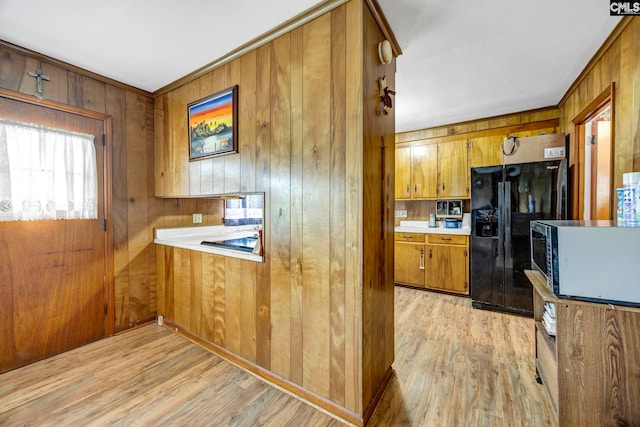 3204 Windmill Rd, Leesville, SC 29070 - kitchen featuring black fridge with ice dispenser, brown cabinets, light wood-type flooring, wooden walls, and light countertops