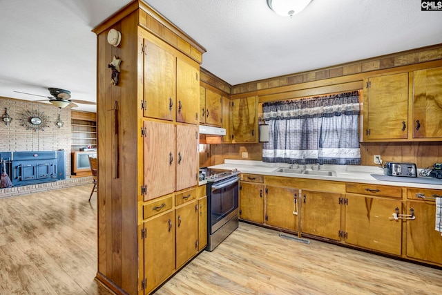 3204 Windmill Rd, Leesville, SC 29070 - kitchen with stainless steel electric range oven, under cabinet range hood, brown cabinets, and light wood-style floors