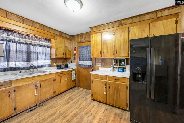 3204 Windmill Rd, Leesville, SC 29070 - kitchen with black refrigerator with ice dispenser, brown cabinets, and wood walls