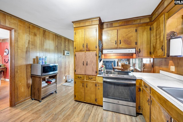 3204 Windmill Rd, Leesville, SC 29070 - kitchen featuring stainless steel appliances, brown cabinetry, wood walls, and light wood-style floors