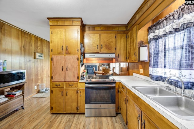 3204 Windmill Rd, Leesville, SC 29070 - kitchen featuring appliances with stainless steel finishes, brown cabinetry, exhaust hood, light wood finished floors, and wooden walls