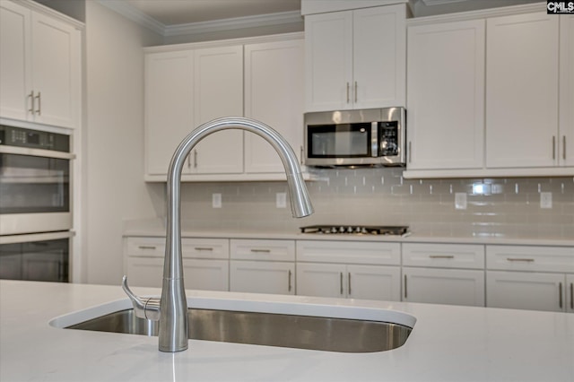 20 Belfast Ct, North Augusta, SC 29860 - kitchen with stainless steel appliances, white cabinets, ornamental molding, and decorative backsplash