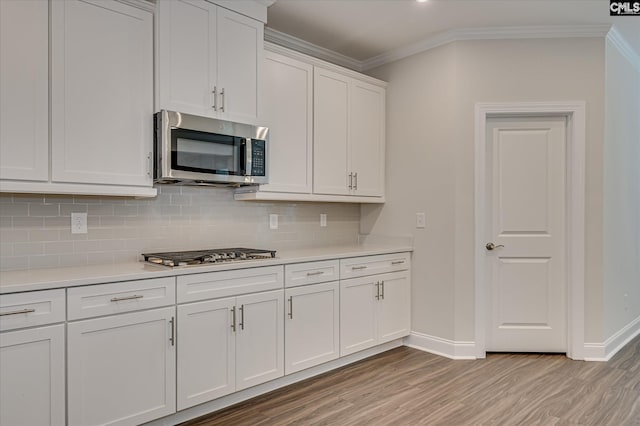 20 Belfast Ct, North Augusta, SC 29860 - kitchen featuring appliances with stainless steel finishes, light wood-style flooring, ornamental molding, light countertops, and tasteful backsplash