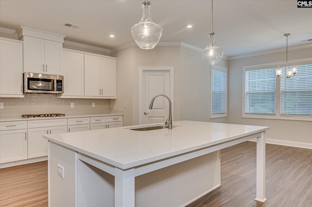 20 Belfast Ct, North Augusta, SC 29860 - kitchen with stainless steel microwave, light wood-style flooring, ornamental molding, tasteful backsplash, and light countertops
