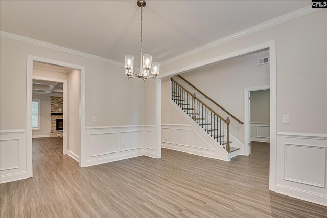 20 Belfast Ct, North Augusta, SC 29860 - spare room featuring stairs, a decorative wall, wood finished floors, a chandelier, and ornamental molding