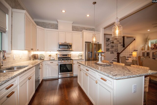 221 Coldwater Xing, Lexington, SC 29072 - kitchen featuring stainless steel appliances, backsplash, white cabinetry, light stone counters, and a center island