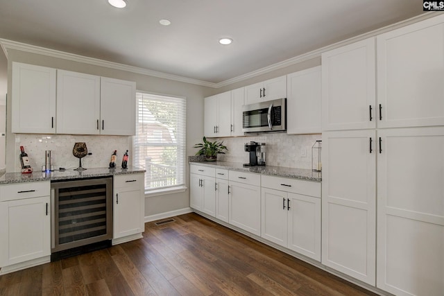 1601 Hagood Ave, Columbia, SC 29204 - kitchen featuring stainless steel microwave, wine cooler, white cabinetry, dark wood-type flooring, and ornamental molding