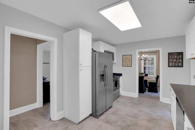 608 Byron Rd, Columbia, SC 29209 - kitchen featuring stainless steel appliances, white cabinets, dark countertops, and a chandelier