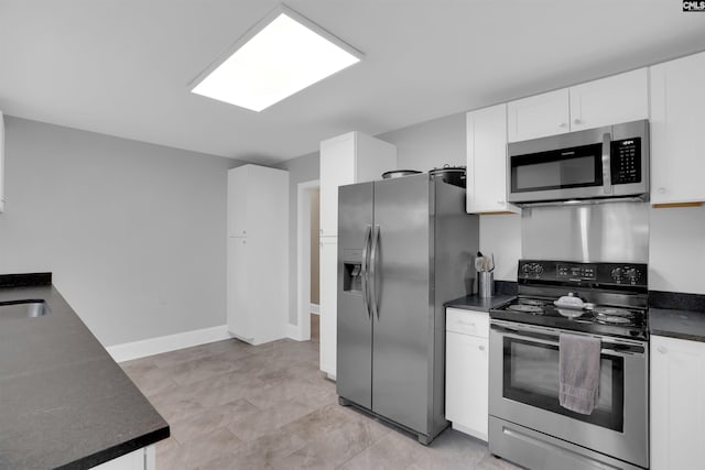 608 Byron Rd, Columbia, SC 29209 - kitchen featuring appliances with stainless steel finishes, dark countertops, and white cabinets