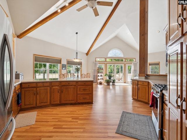 887 Living Waters, Great Falls, SC 29055 - kitchen featuring appliances with stainless steel finishes, brown cabinetry, high vaulted ceiling, light wood finished floors, and light countertops