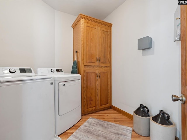 887 Living Waters, Great Falls, SC 29055 - washroom with washer and clothes dryer, light wood finished floors, and cabinet space