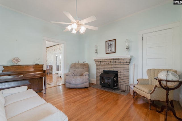 232 Boulware Rd, Lugoff, SC 29078 - living area featuring light wood-type flooring, a ceiling fan, ornamental molding, and a wood stove