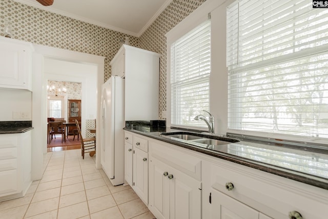 232 Boulware Rd, Lugoff, SC 29078 - kitchen with wallpapered walls, freestanding refrigerator, ornamental molding, light tile patterned floors, and white cabinetry