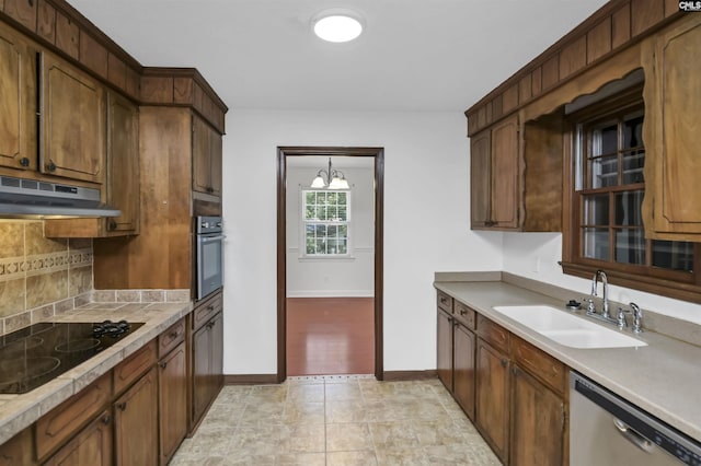 136 Traylors Gate Cir, Irmo, SC 29063 - kitchen featuring stainless steel appliances, under cabinet range hood, decorative backsplash, light countertops, and a chandelier