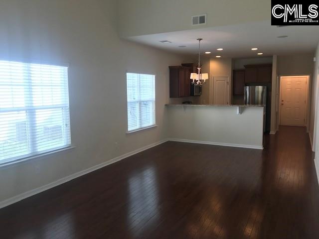 532 Slices Way, Chapin, SC 29036 - kitchen featuring freestanding refrigerator, dark wood finished floors, a peninsula, a chandelier, and a kitchen bar