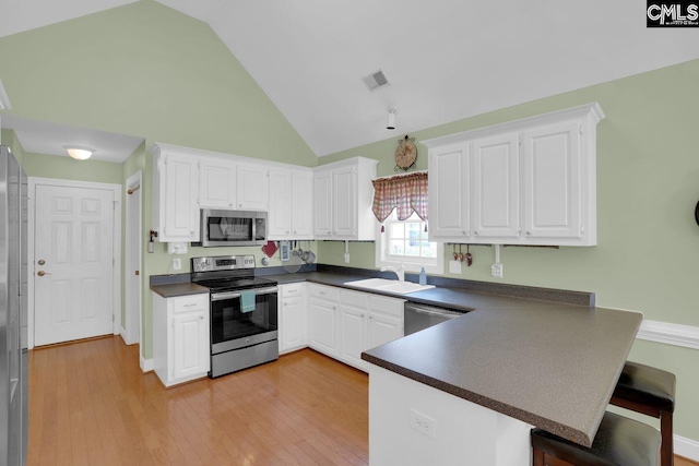 430 Plantation Pointe Dr, Elgin, SC 29045 - kitchen featuring stainless steel appliances, dark countertops, a peninsula, white cabinetry, and high vaulted ceiling