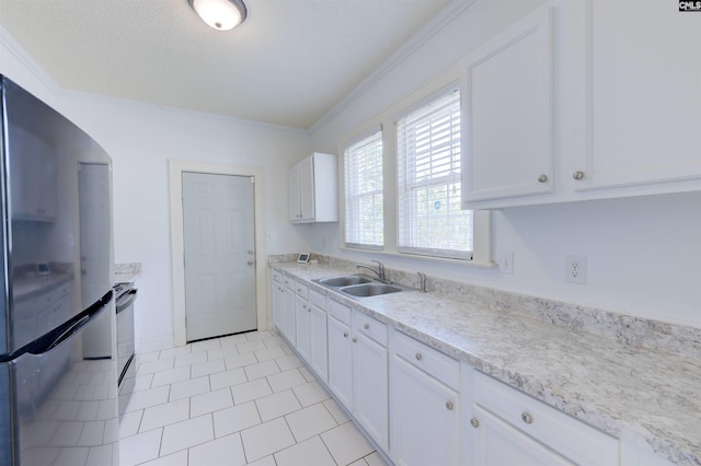 2500 Waites Rd, Columbia, SC 29204 - kitchen with freestanding refrigerator, ornamental molding, plenty of natural light, white cabinetry, and light tile patterned floors