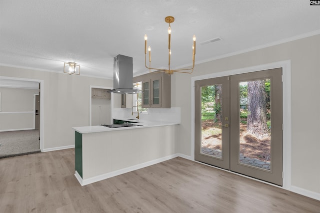 898 Perry Blvd, Sumter, SC 29154 - kitchen with island range hood, crown molding, light wood finished floors, light countertops, and french doors